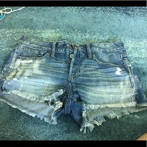 High rise distressed medium denim shorts.